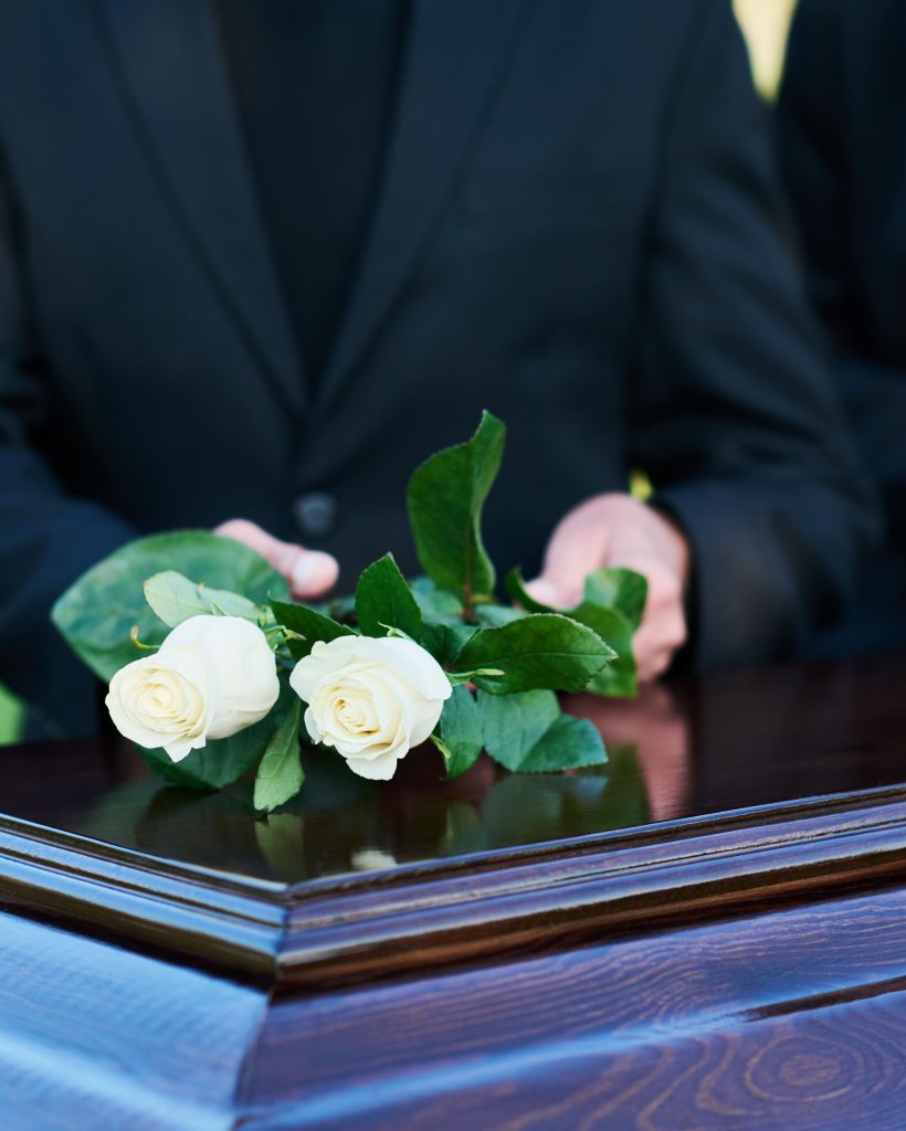 focus-two-fresh-white-roses-being-put-coffin-lid-by-mature-man